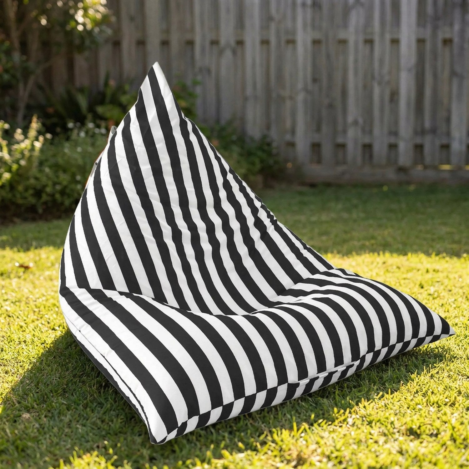 Housse de pouf géant extérieur rayée noire sur une pelouse