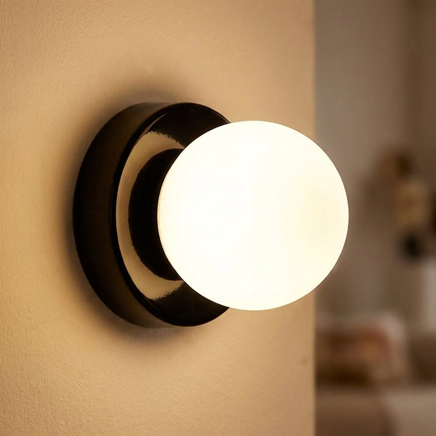Applique murale noire avec globe en verre allumé gros plan