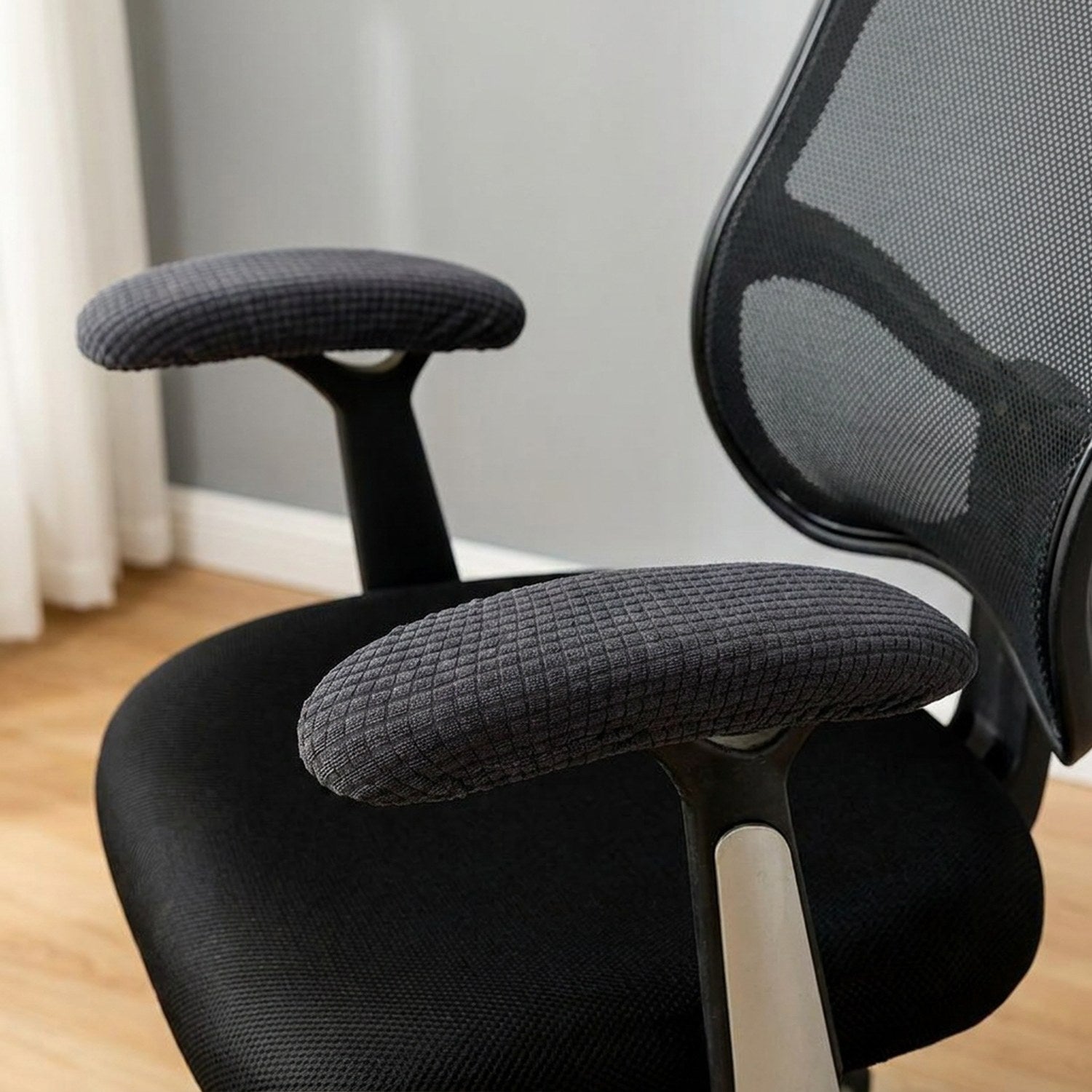 Paire de housses d'accoudoir gris foncé en tissu texture installees sur une chaise de bureau