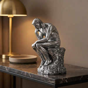 Statue Le Penseur de Rodin finition argentée sur une console en marbre