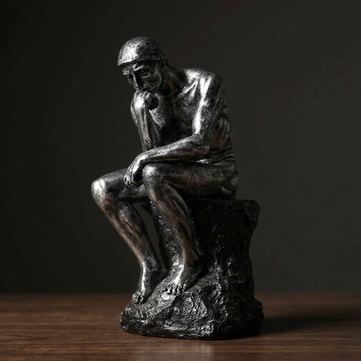 Statue de penseur en résine coloris Argenté gros plan sur fond sombre