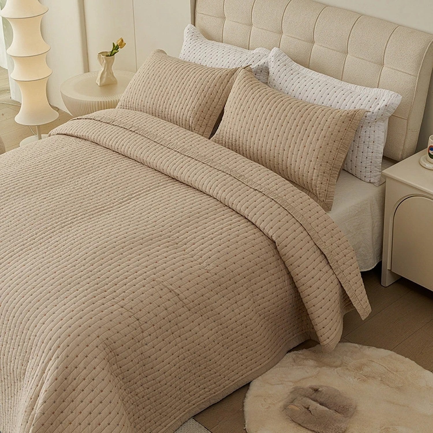 Couvre-lit matelassé beige à motif pointillé matelassé installé sur un lit fait