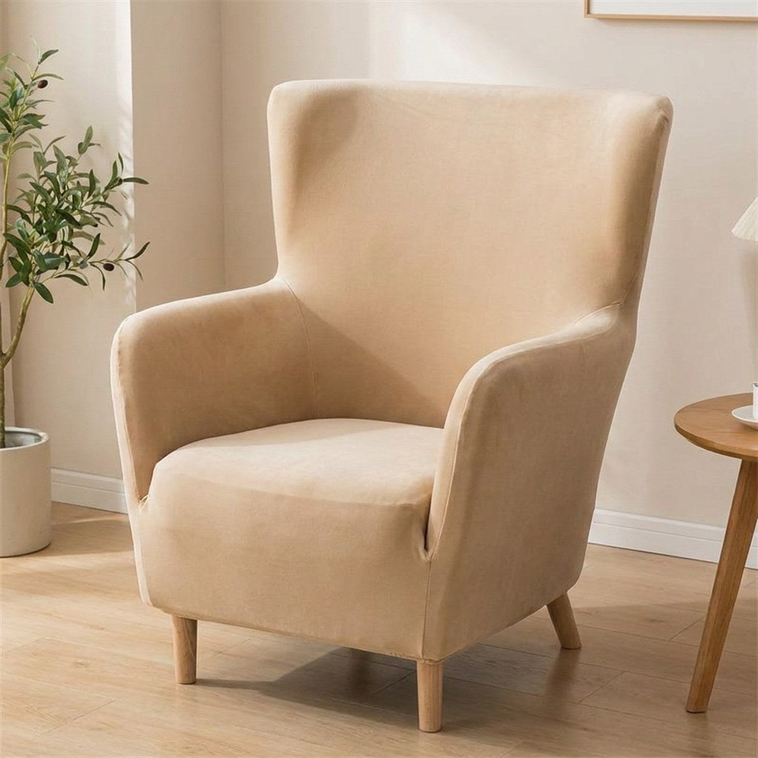 Housse de fauteuil à oreilles en velours beige sur un fauteuil une place