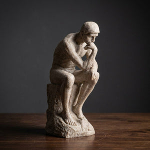 Statue de penseur en résine coloris Beige gros plan sur fond sombre