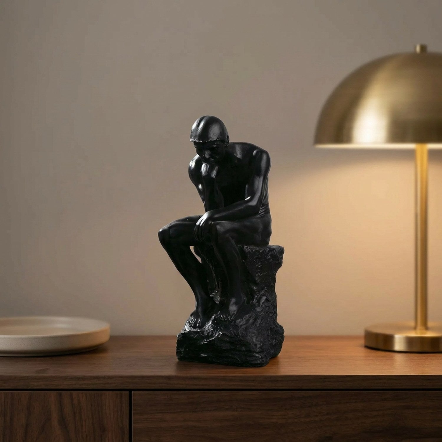 Statue Le Penseur de Rodin en résine noire sur une console en bois