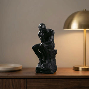 Statue Le Penseur de Rodin en résine noire sur une console en bois