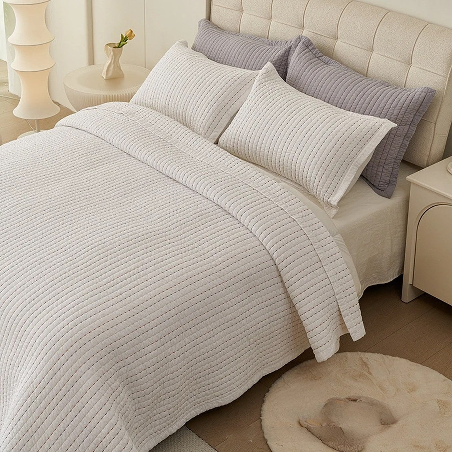 Couvre-lit matelassé blanc à fines lignes matelassées installé sur un lit fait