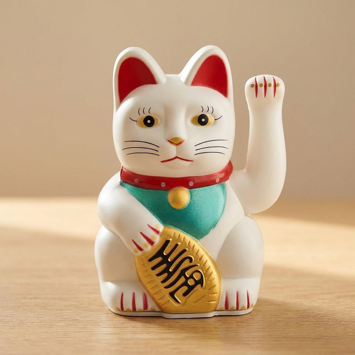 Figurine chat porte-bonheur blanc posé sur une surface en bois clair