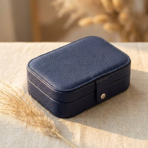 Boîte à bijoux voyage bleu marine en simili cuir sur surface lin