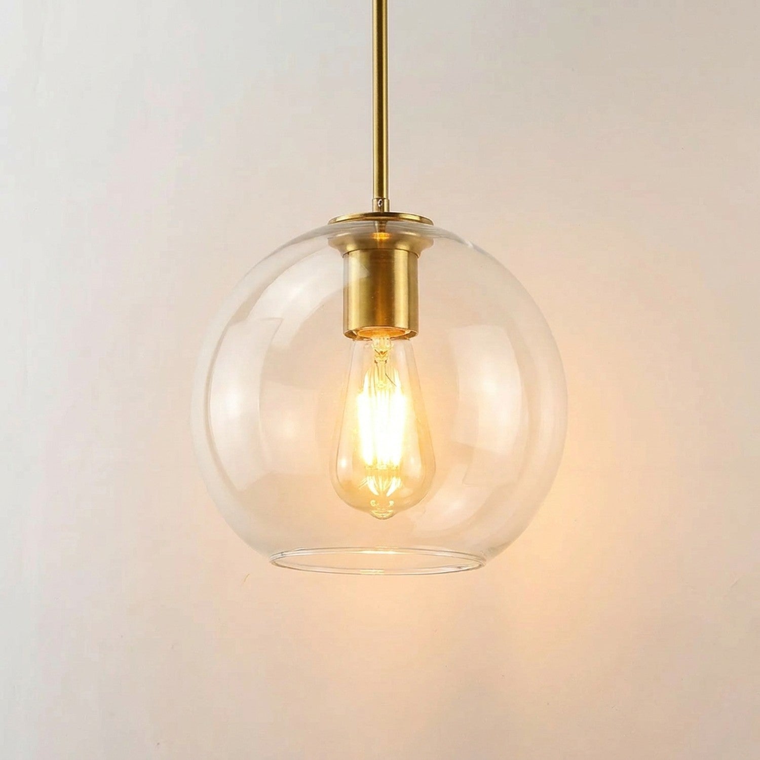 Suspension boule de verre transparent avec armature dorée allumée