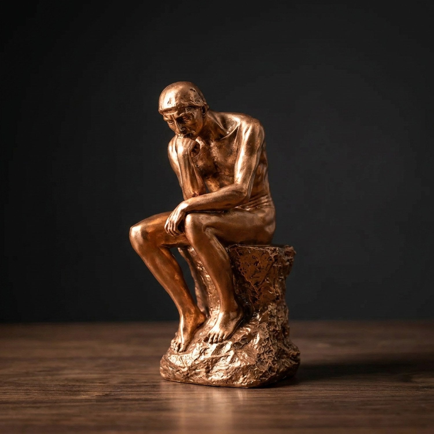 Statue de penseur en résine coloris Doré gros plan sur fond sombre