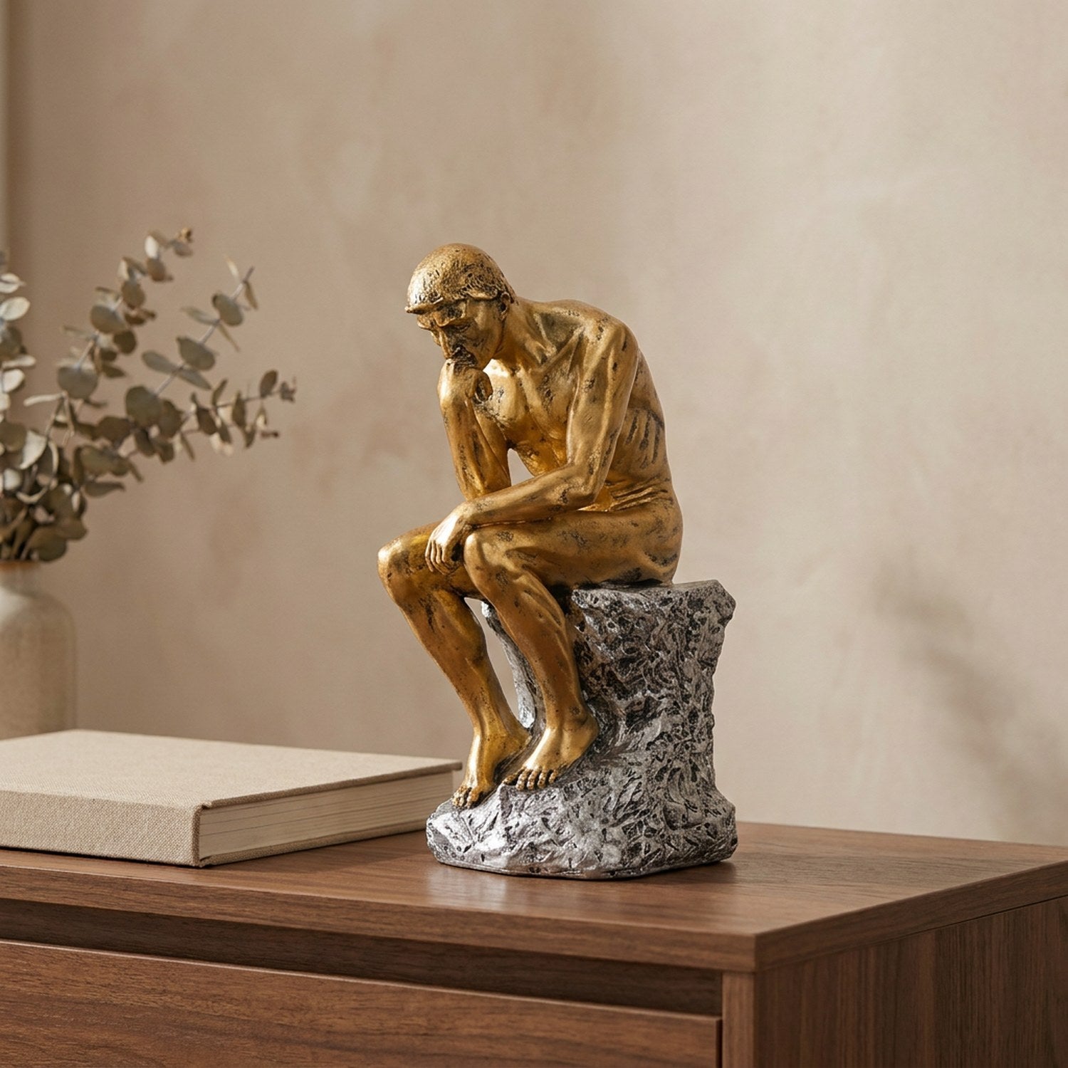 Statue Le Penseur de Rodin finition dorée sur une console en bois