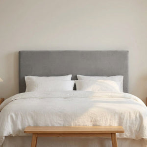 Housse de tête de lit en velours gris vue de face sur un lit