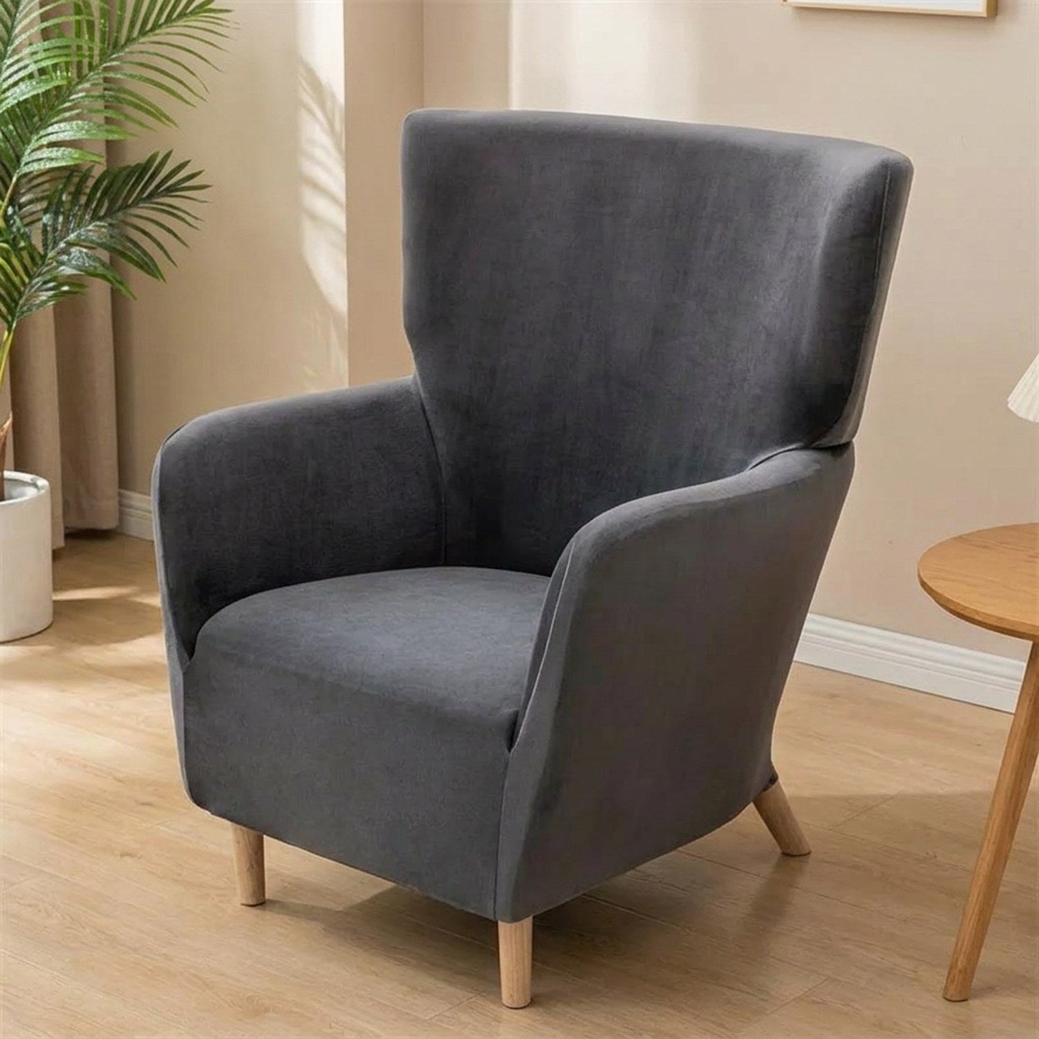 Housse de fauteuil à oreilles en velours gris anthracite sur un fauteuil une place