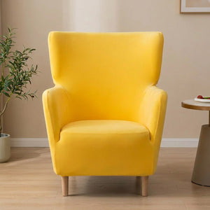 Housse de fauteuil à oreilles en velours jaune sur un fauteuil une place