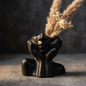 Vase céramique visage abstrait noir fond béton