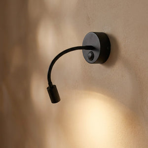 Applique murale liseuse noire bras 38 cm allumée sur un mur