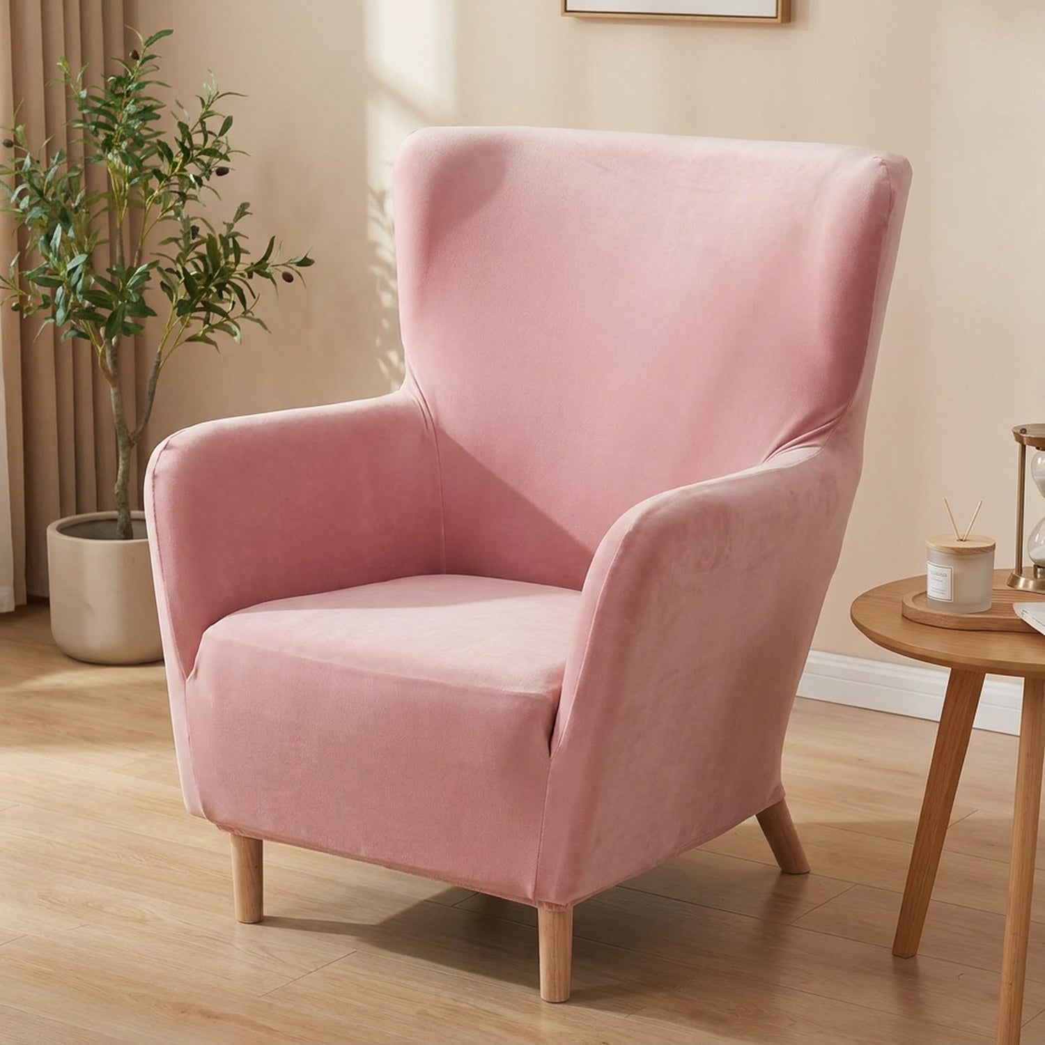 Housse de fauteuil à oreilles en velours rose sur un fauteuil une place