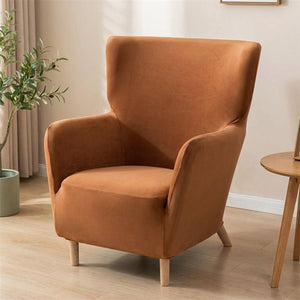 Housse de fauteuil à oreilles en velours terracotta sur un fauteuil une place