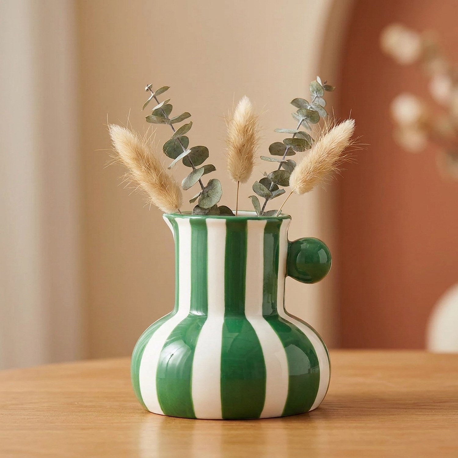 Petit vase en céramique à rayures vertes avec une bille verte sur le côté