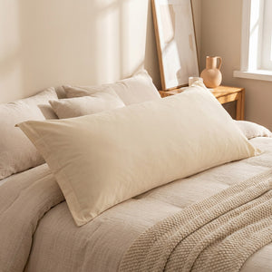 Taie d'oreiller longue couleur beige gros plan sur lit