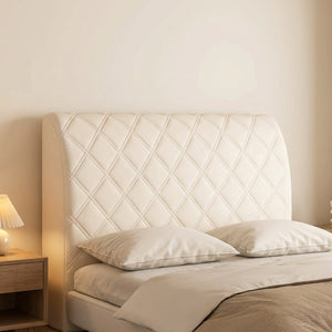 Housse de tête de lit couleur beige installée sur un lit avec lampe de chevet