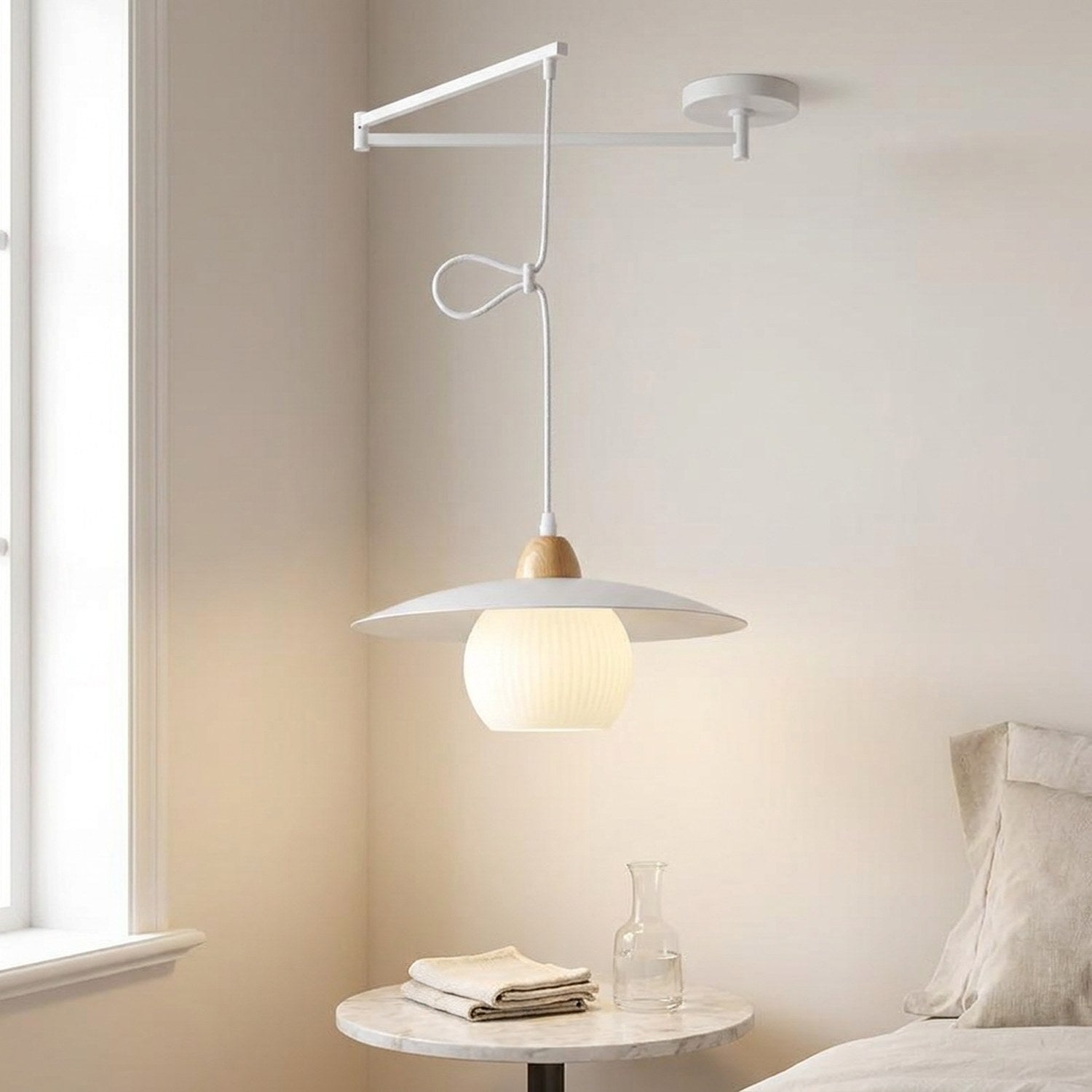 Lampe suspendue blanche, abat-jour globe en verre, dans une chambre lumineuse