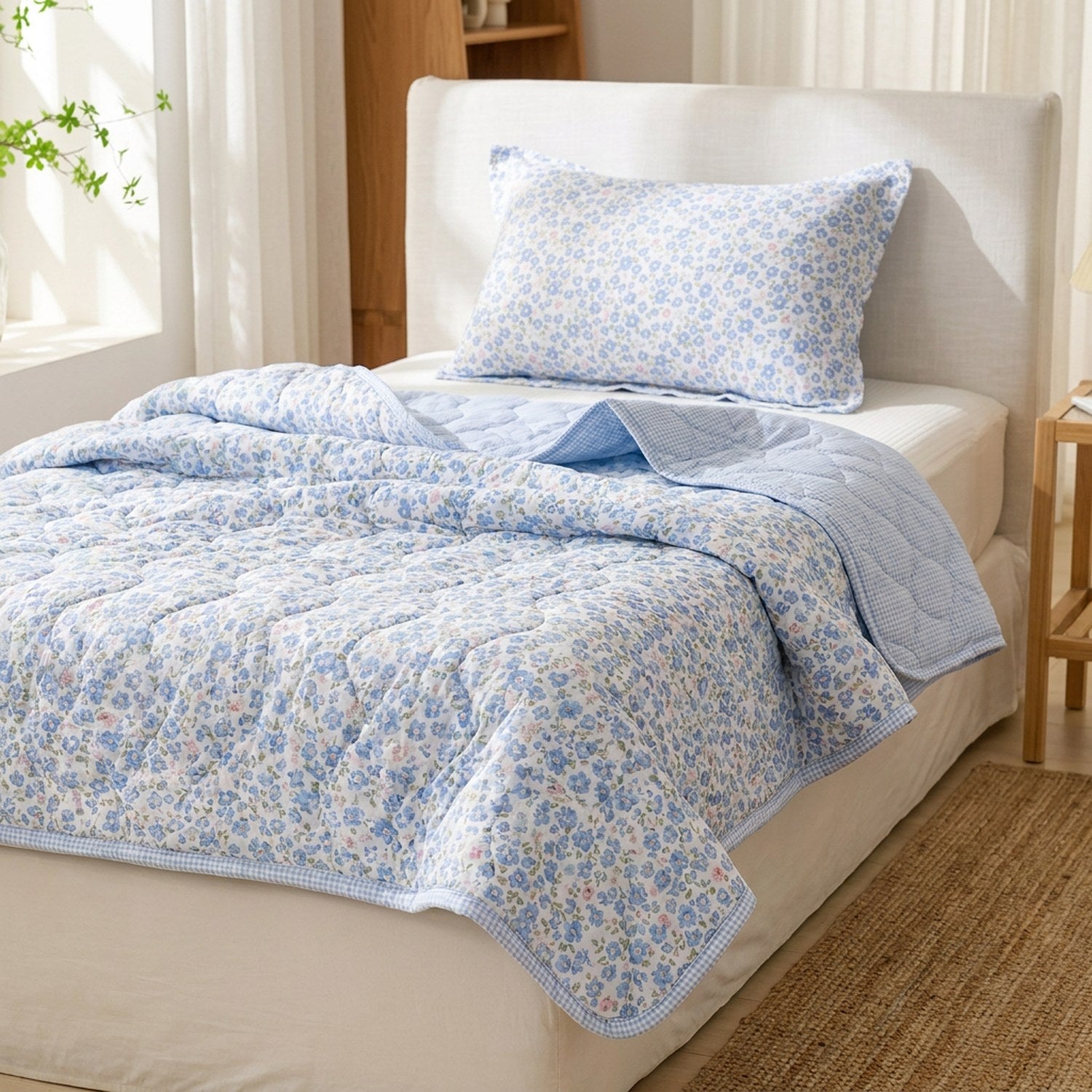 Couette d'été matelassée bleue à motif floral installée sur un lit