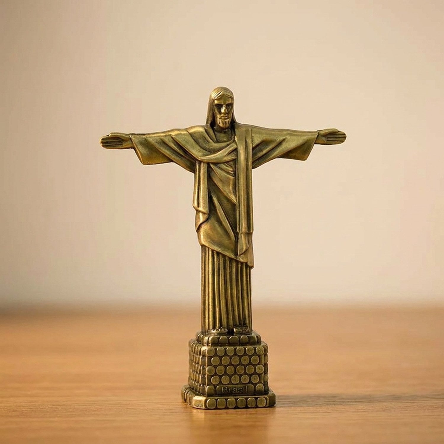 Statuette Christ Rédempteur finition bronze ancien patine verte et or sur surface bois