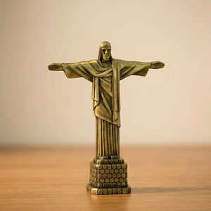 Statuette Christ Rédempteur finition bronze ancien patine verte et or sur surface bois