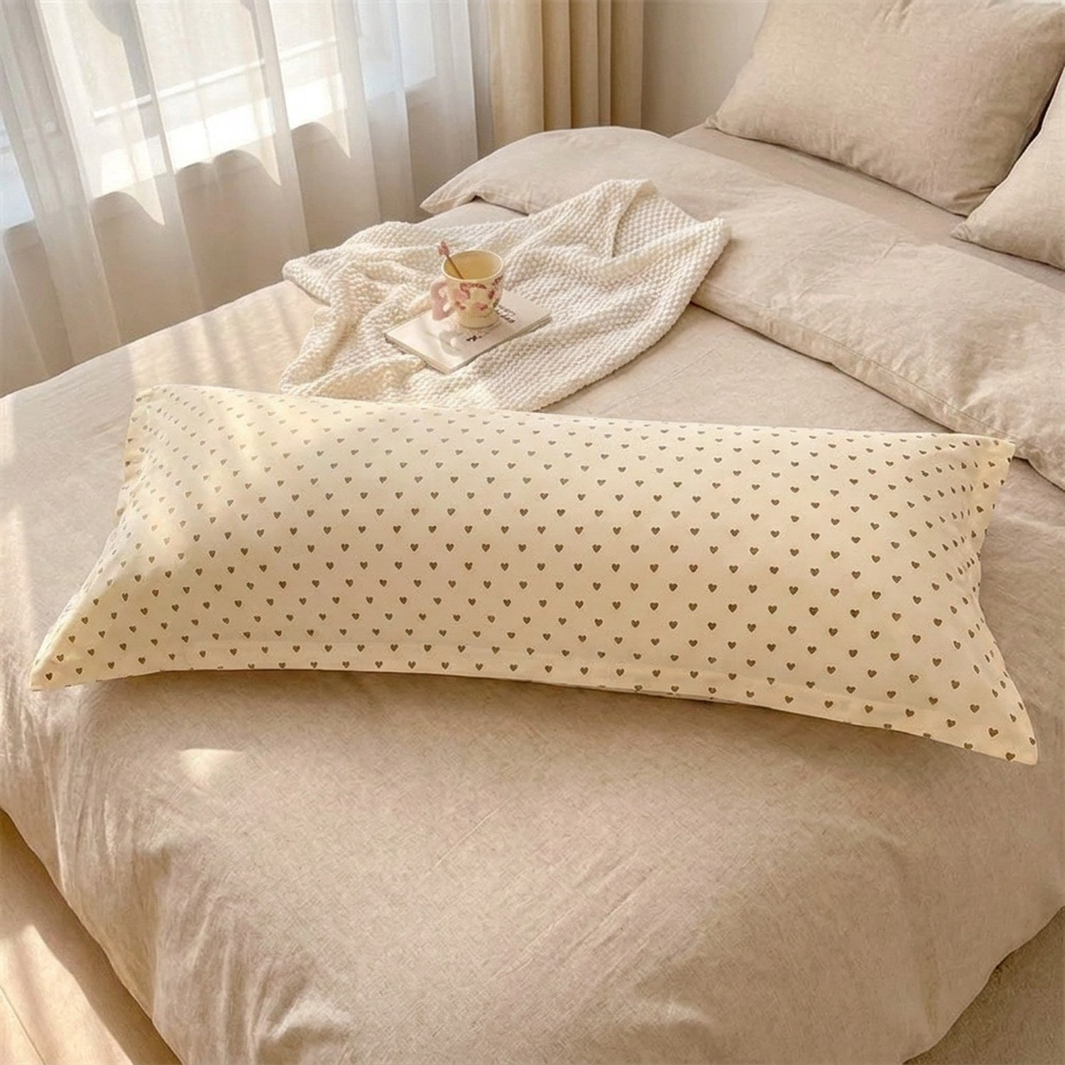 Taie d'oreiller longue imprimée cœurs sur un lit chambre cocooning