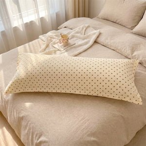 Taie d'oreiller longue imprimée cœurs sur un lit chambre cocooning