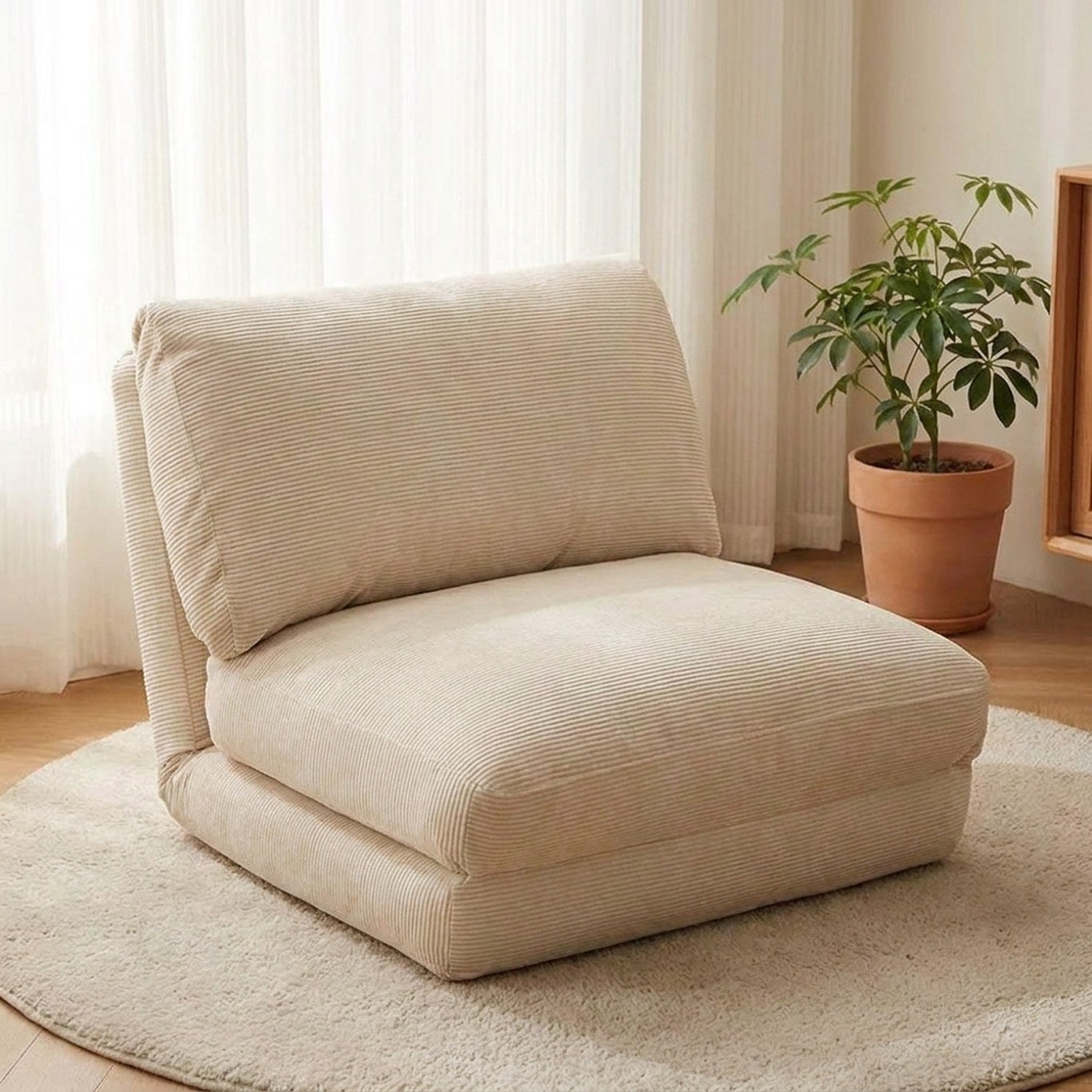 Fauteuil de sol pliable en velours côtelé crème dans un intérieur minimaliste
