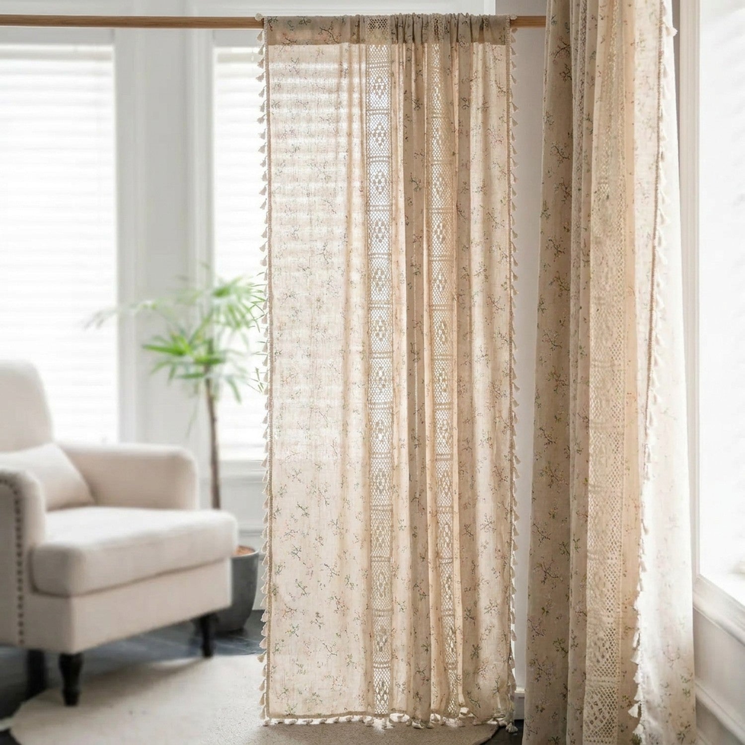 Rideau boho en lin fleurs et dentelle à pompons devant une fenêtre