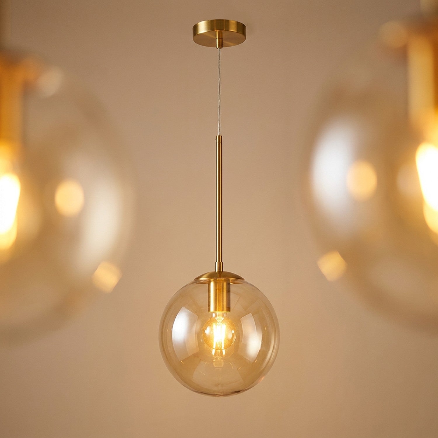 Suspension boule verre transparent finition dorée luminaire design