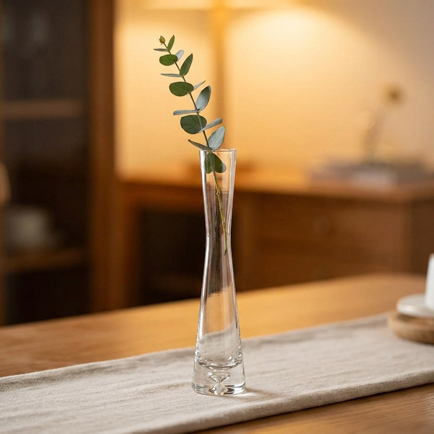 Vase soliflore en verre modèle bouche droite avec une tige d'eucalyptus