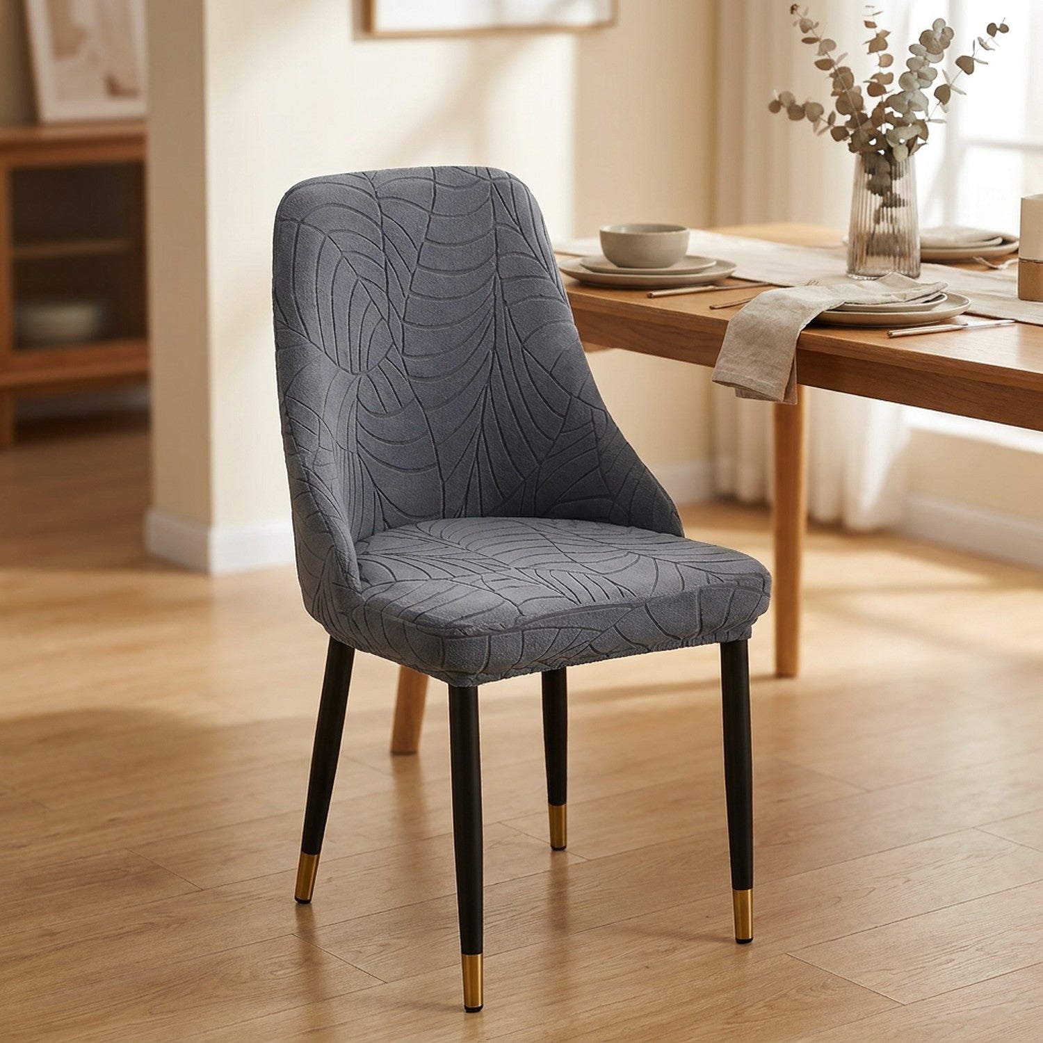 Housse de chaise extensible en jacquard gris au motif feuilles sur une chaise incurvée