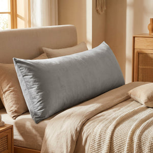 Housse de coussin en velours gris vue de face sur un lit