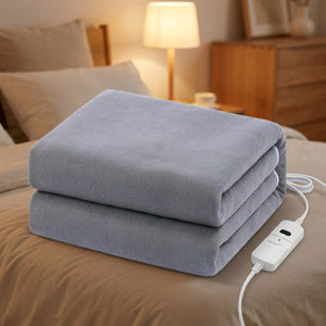 Couverture chauffante grise unie pliée sur un lit