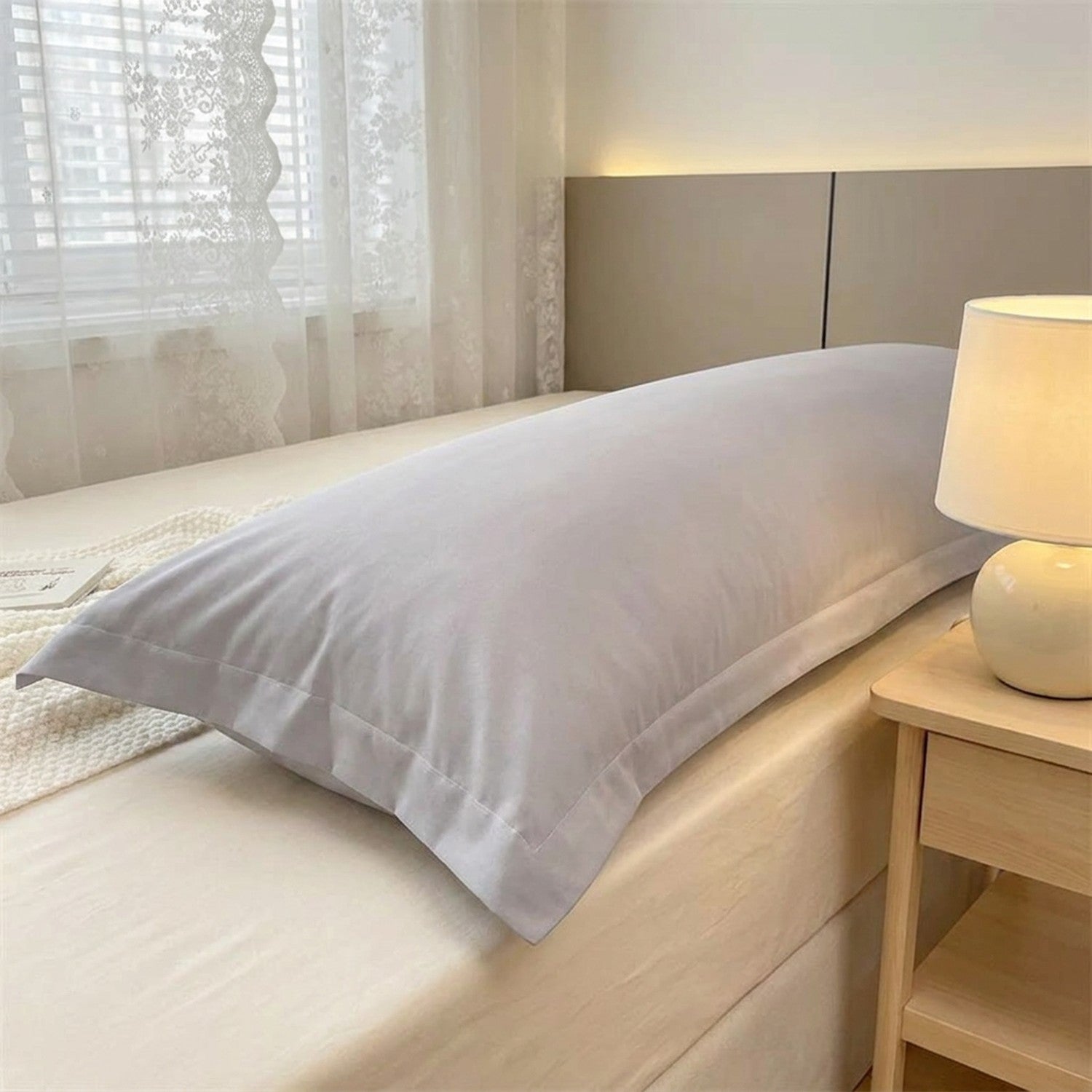 Taie de traversin longue en microfibre grise sur un lit