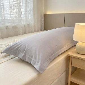 Taie de traversin longue en microfibre grise sur un lit