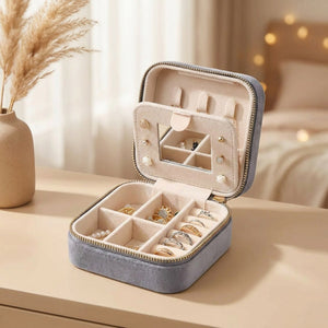 Boîte à bijoux de voyage en velours gris ouverte avec miroir et rangements