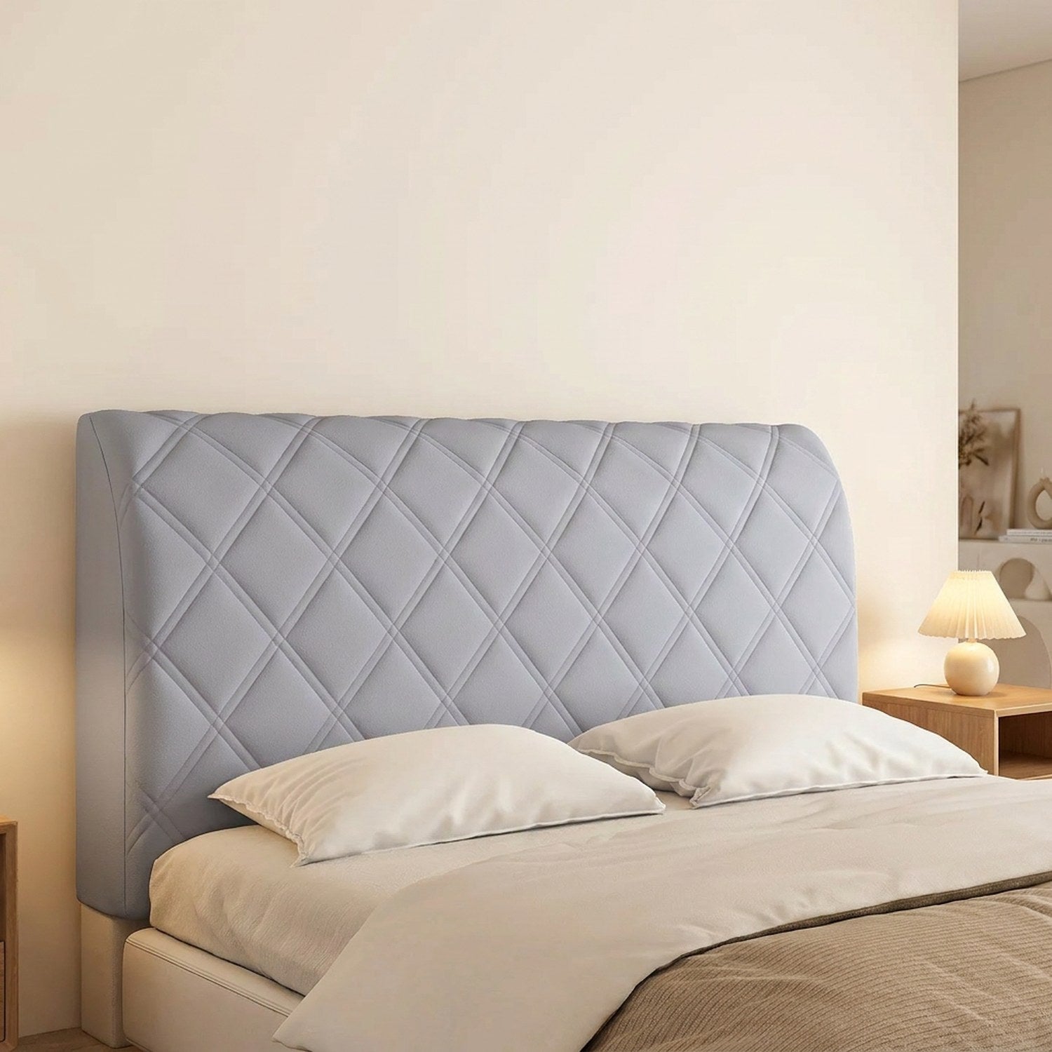 Housse de tête de lit couleur grise installée sur un lit avec lampe de chevet