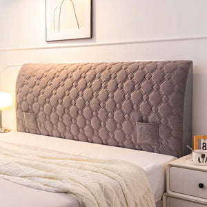 Housse de tête de lit matelassée grise dans une chambre chaleureuse