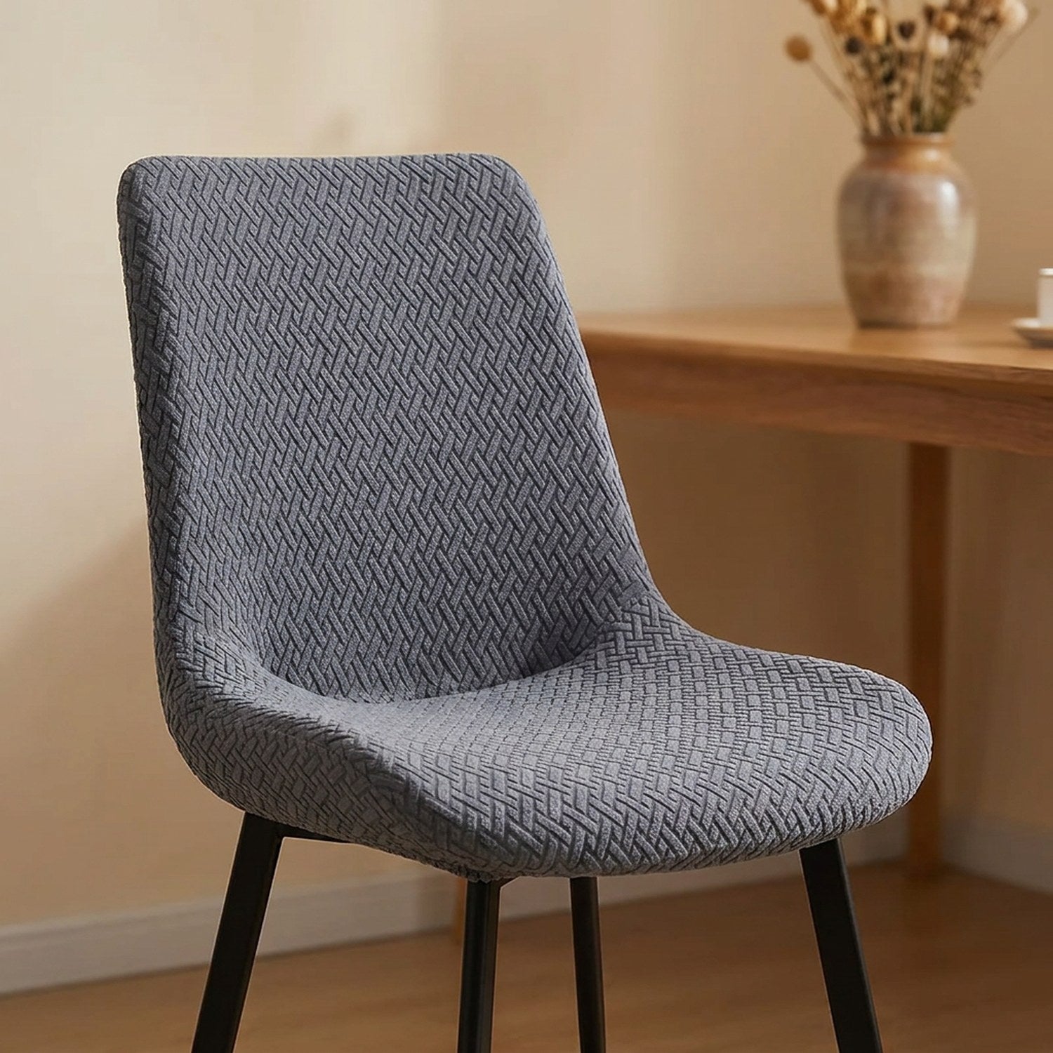 Housse de chaise jacquard grise sur une chaise dans un intérieur chaleureux