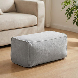 Pouf repose-pieds en chenille gris clair dans un salon lumineux