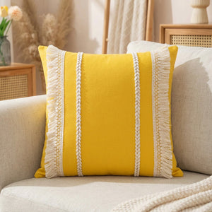 Housse de coussin bohème jaune moutarde tissée à franges sur un canapé en lin