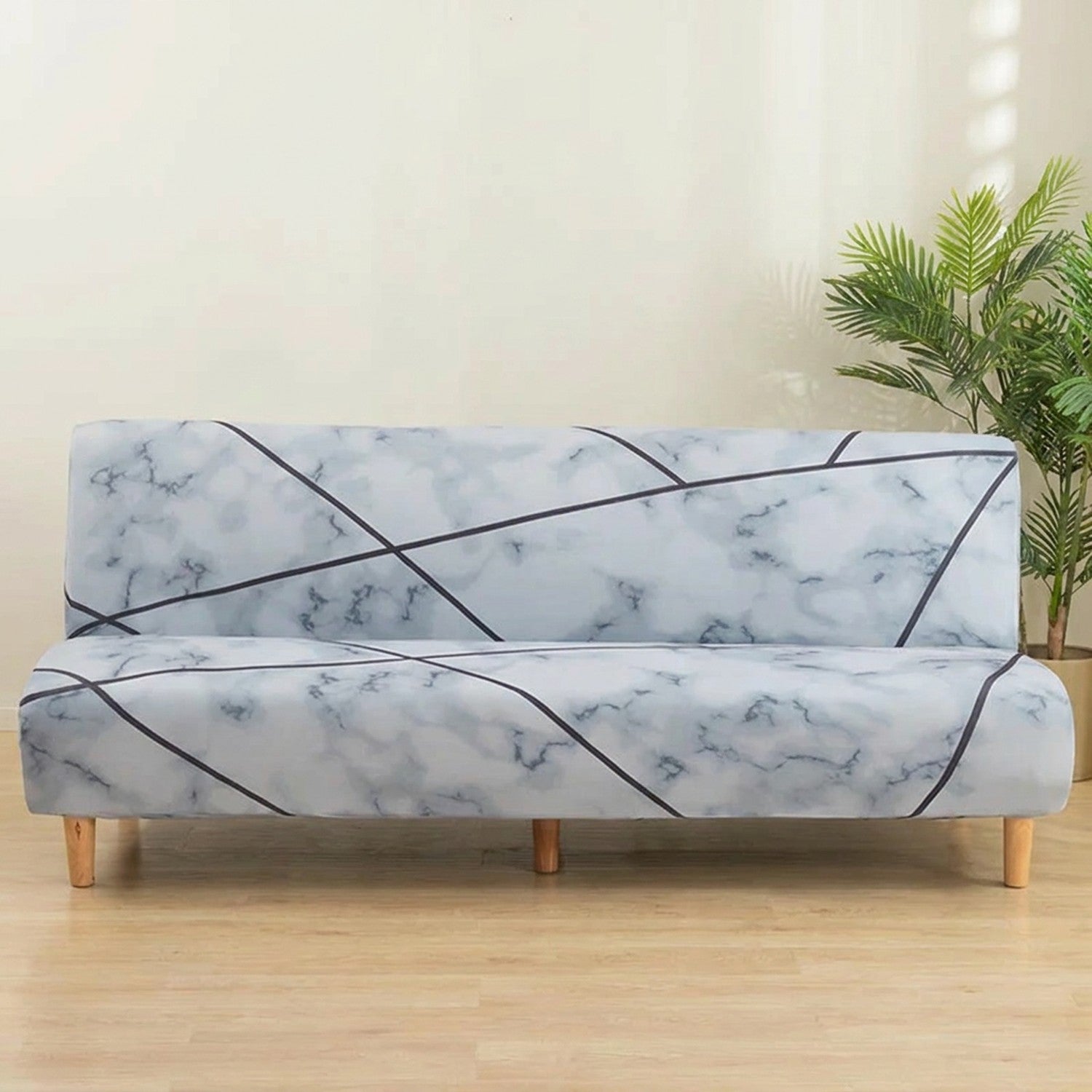Housse de canapé extensible effet marbre blanc et gris clair sur une banquette sans accoudoirs