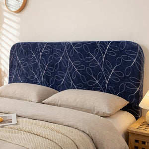 Housse de tête de lit en velours bleu foncé à fines feuilles blanches sur une tête de lit de chambre