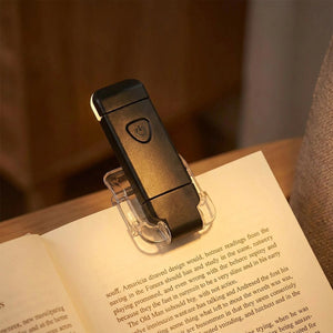 Lampe de lecture noire à pince clipée sur un livre